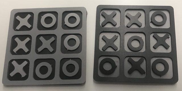 Dos tableros de juego 'tres en raya' con piezas de 'X' y 'O' en negro y gris.