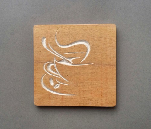 Imagen de una talla de madera con el diseño de una taza de café estilizada.