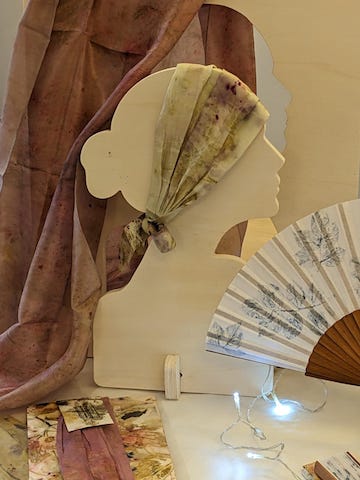 Expositor de tienda con silueta de cabeza femenina en madera, utilizado para mostrar accesorios.